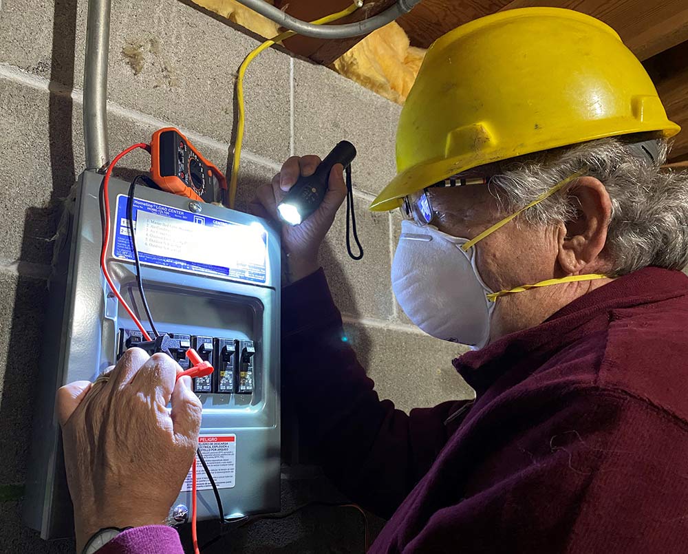 Photo of Mark E. Sostarich checking electrical board in a construction site